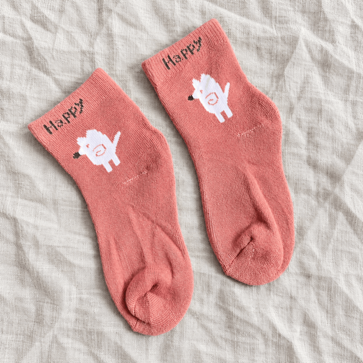 Pink Happy lamb socks on linen