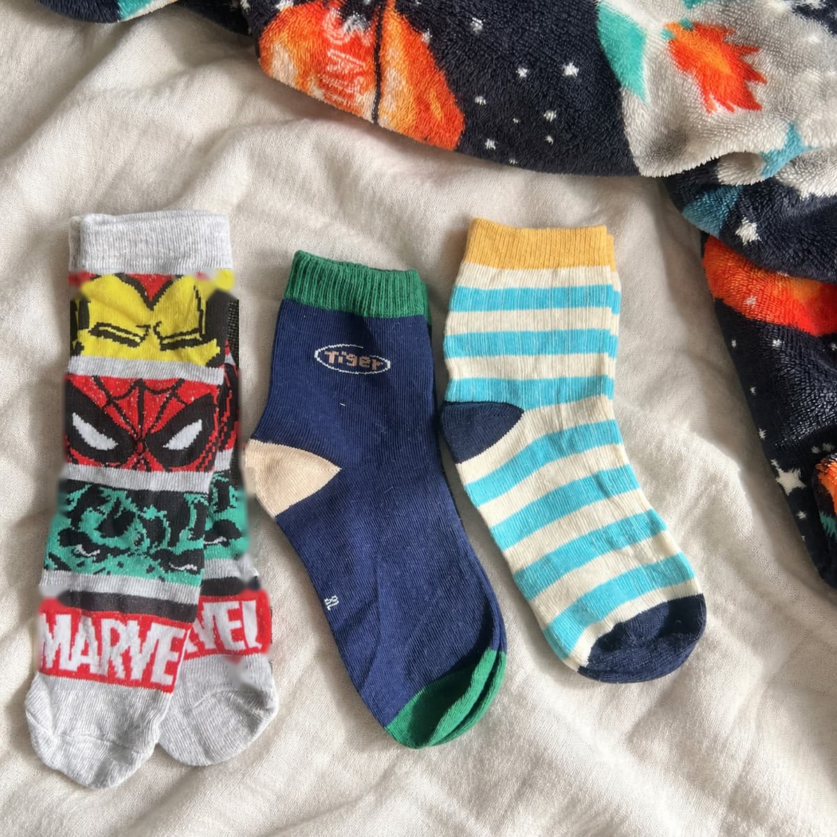 Three pairs of boys socks with Marvel, navy and striped designs