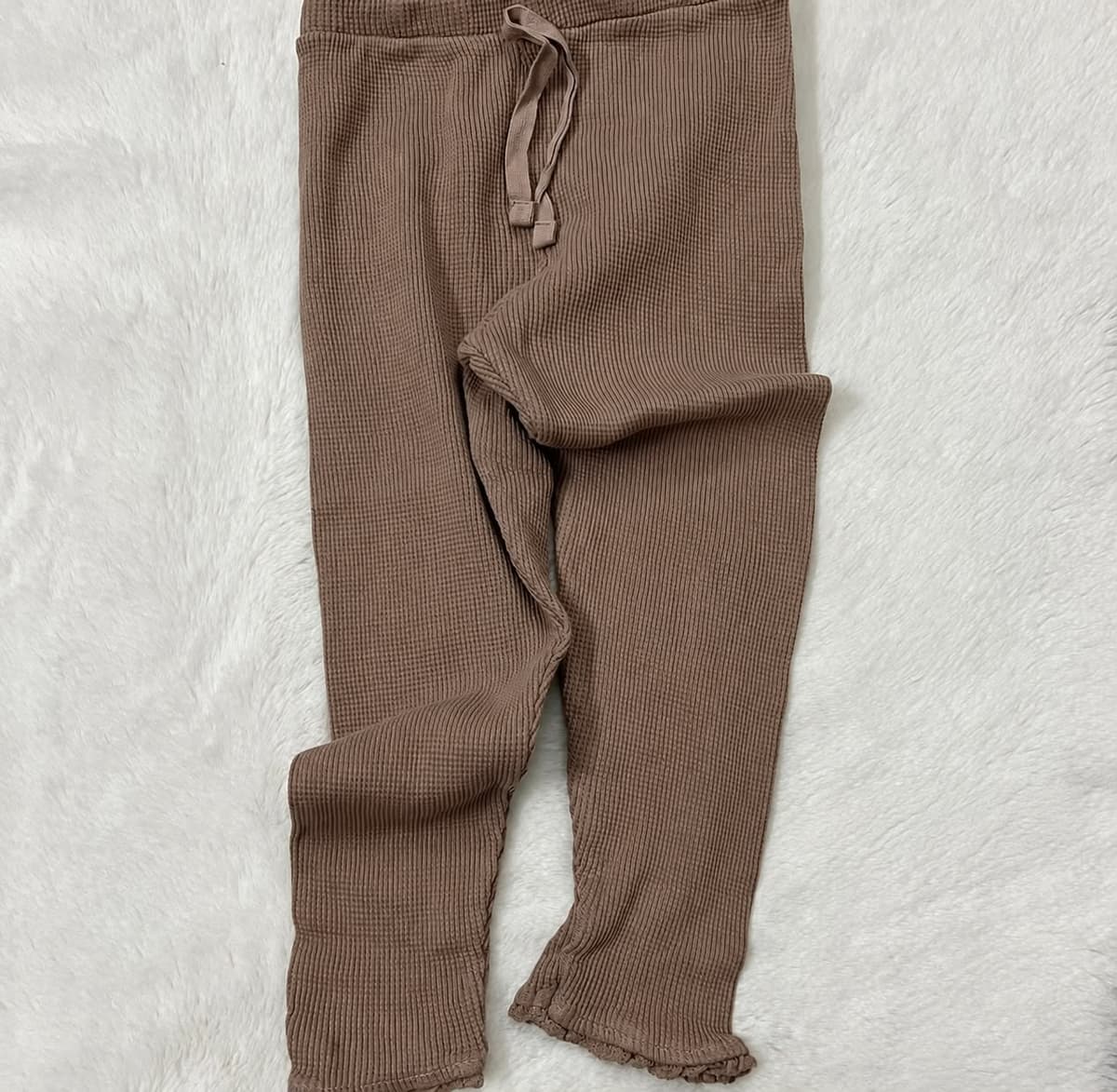 Mocha-brown ribbed girls leggings with a drawstring waist and frilled ankles, laid flat