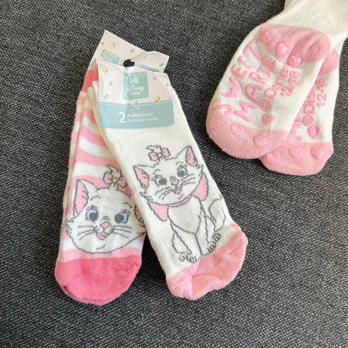 Two pairs of Marie kitten socks in their Disney Baby non-slip pack: pink-and-white stripes, and cream with pink heels and toes