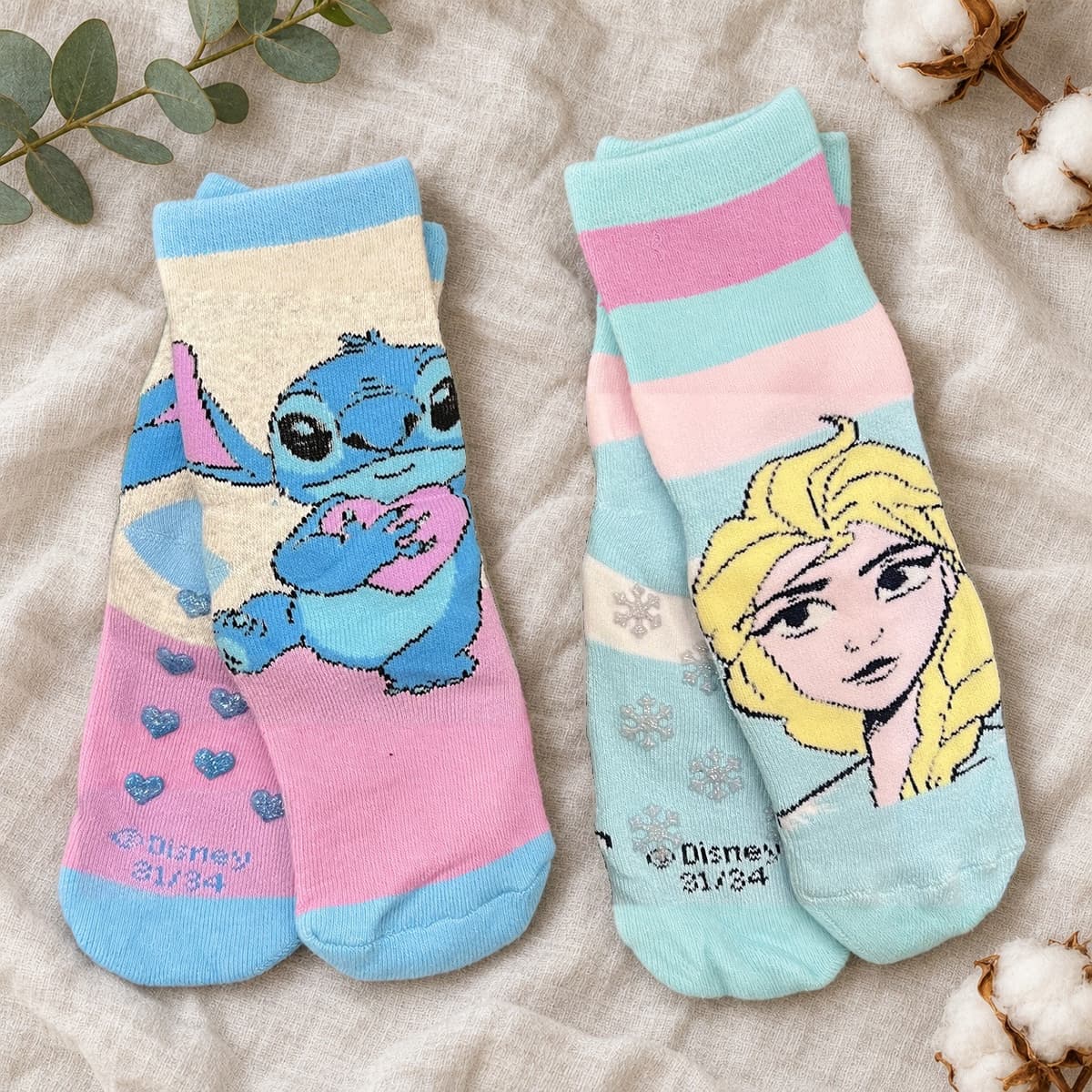 Lilac Stitch and aqua Frozen Elsa socks, two pairs on cream linen with nursery props