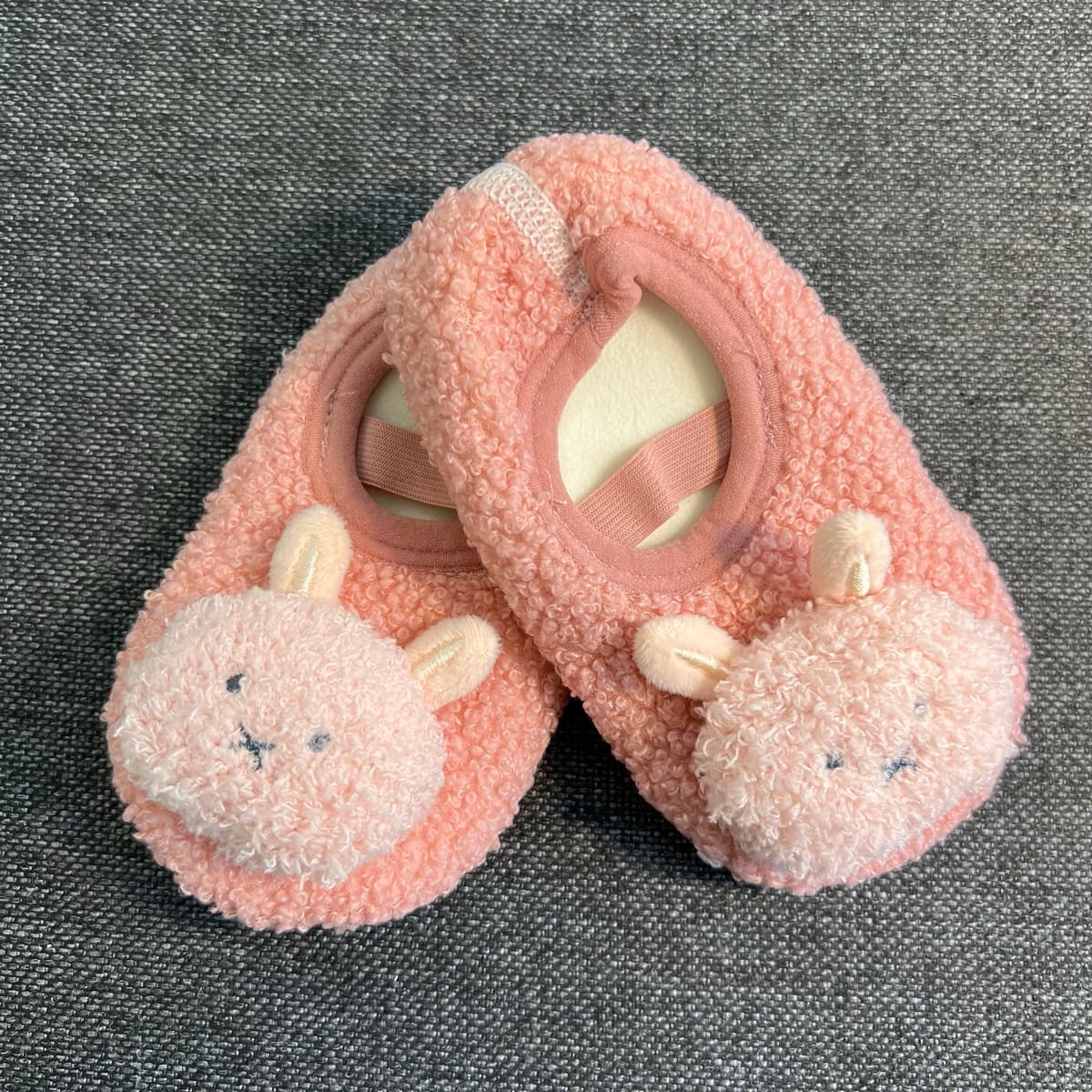 A pair of fluffy pink floor socks with plush bunny faces and pink elastic straps