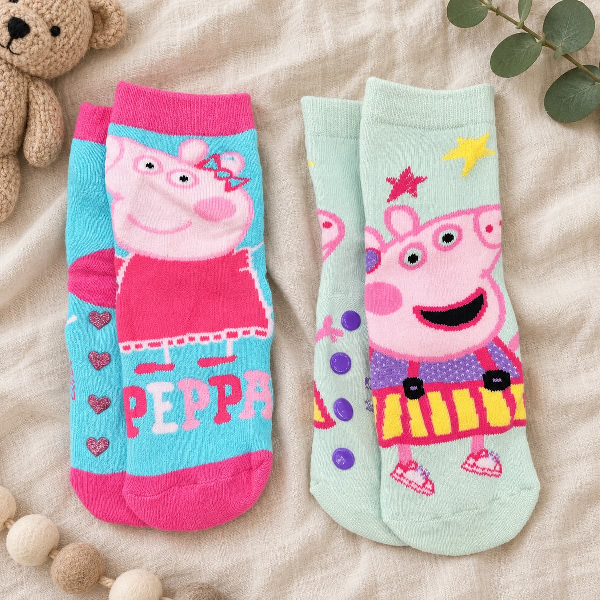 Aqua and mint Peppa Pig socks, two pairs on cream linen with nursery props