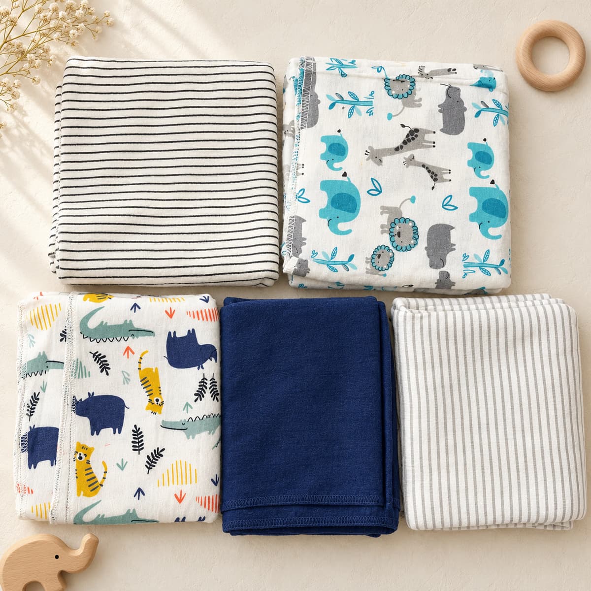 Five folded flannel sheets: black stripes, safari animals, jungle tigers and crocodiles, plain navy and grey stripes