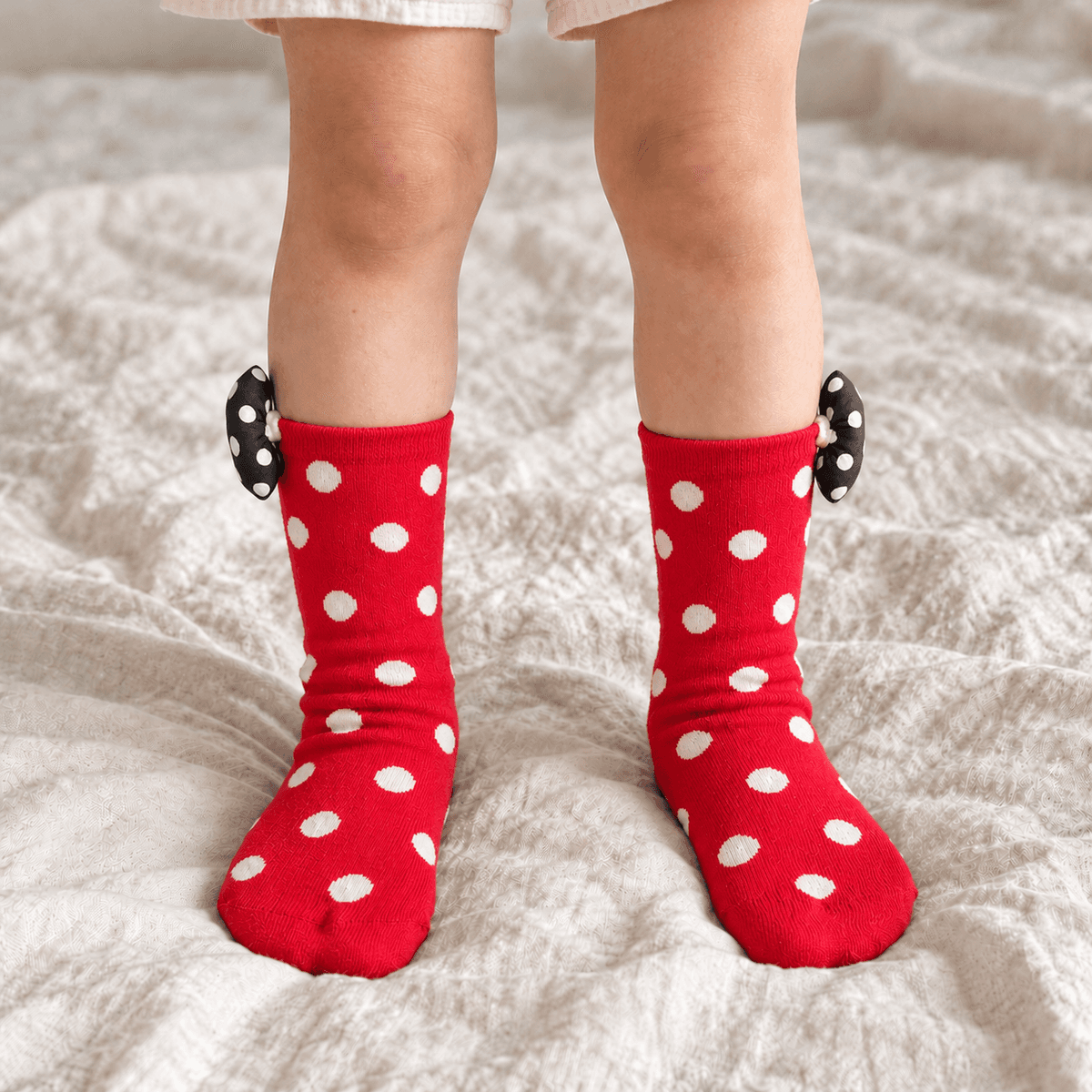 Red polka dot bow socks worn by a child