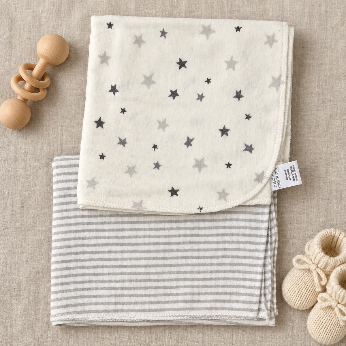 Two flannel sheets: cream with grey stars, and grey and white stripes