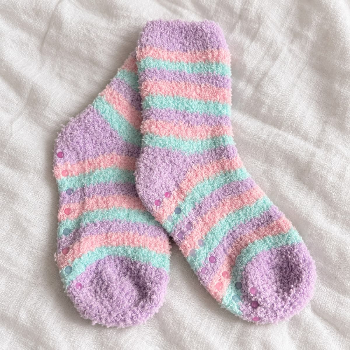 Pastel striped towel-padded anti-slip socks on cream linen