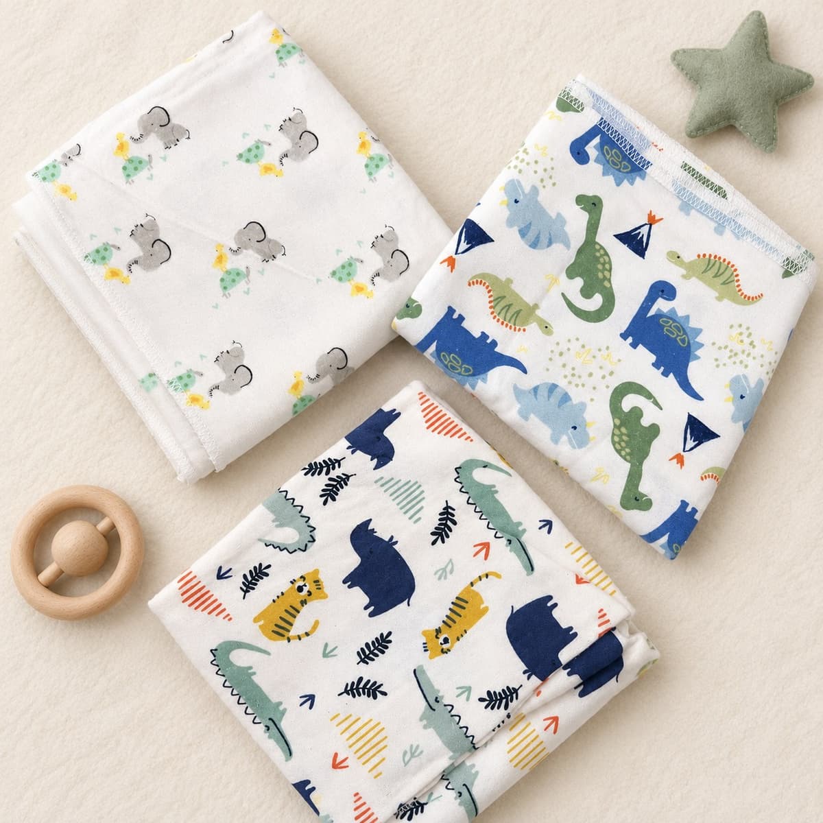 Three folded flannel sheets: white with grey elephants, green turtles and yellow ducklings, white with blue and green dinosaurs, and white with tigers, crocodiles and navy rhinos