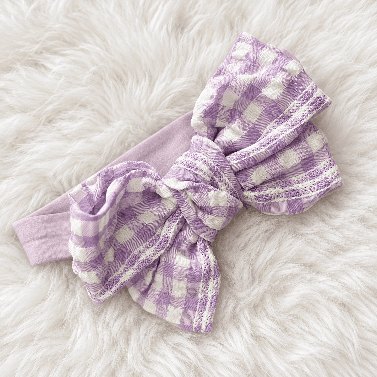 Lilac headband with a big lilac-and-white gingham bow, on white fur