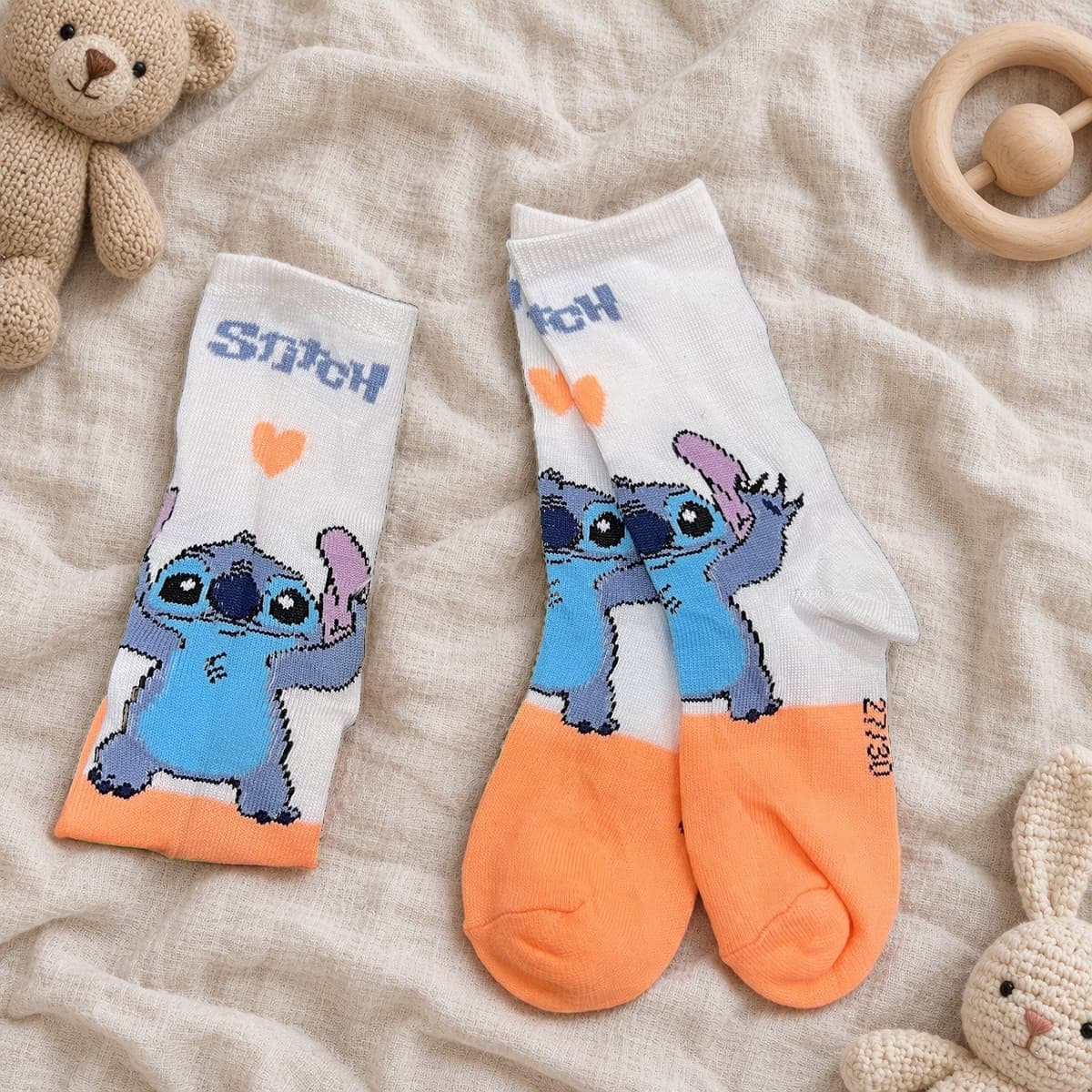 White and peach Stitch socks on cream linen with nursery props
